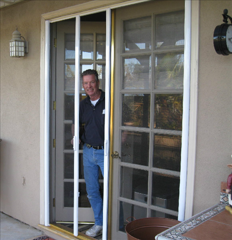 ALL-WAYS SCREENS technician standing behind a retractable entry door screen