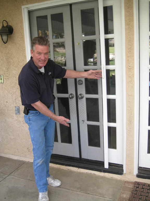 ALL-WAYS SCREENS technician presenting a retractable screen for French doors