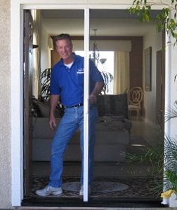 ALL-WAYS SCREENS technician demonstrating a retractable screen at a doorway