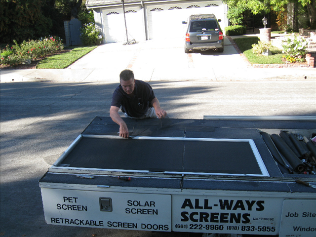 ALL-WAYS SCREENS technician working at the mobile service trailer